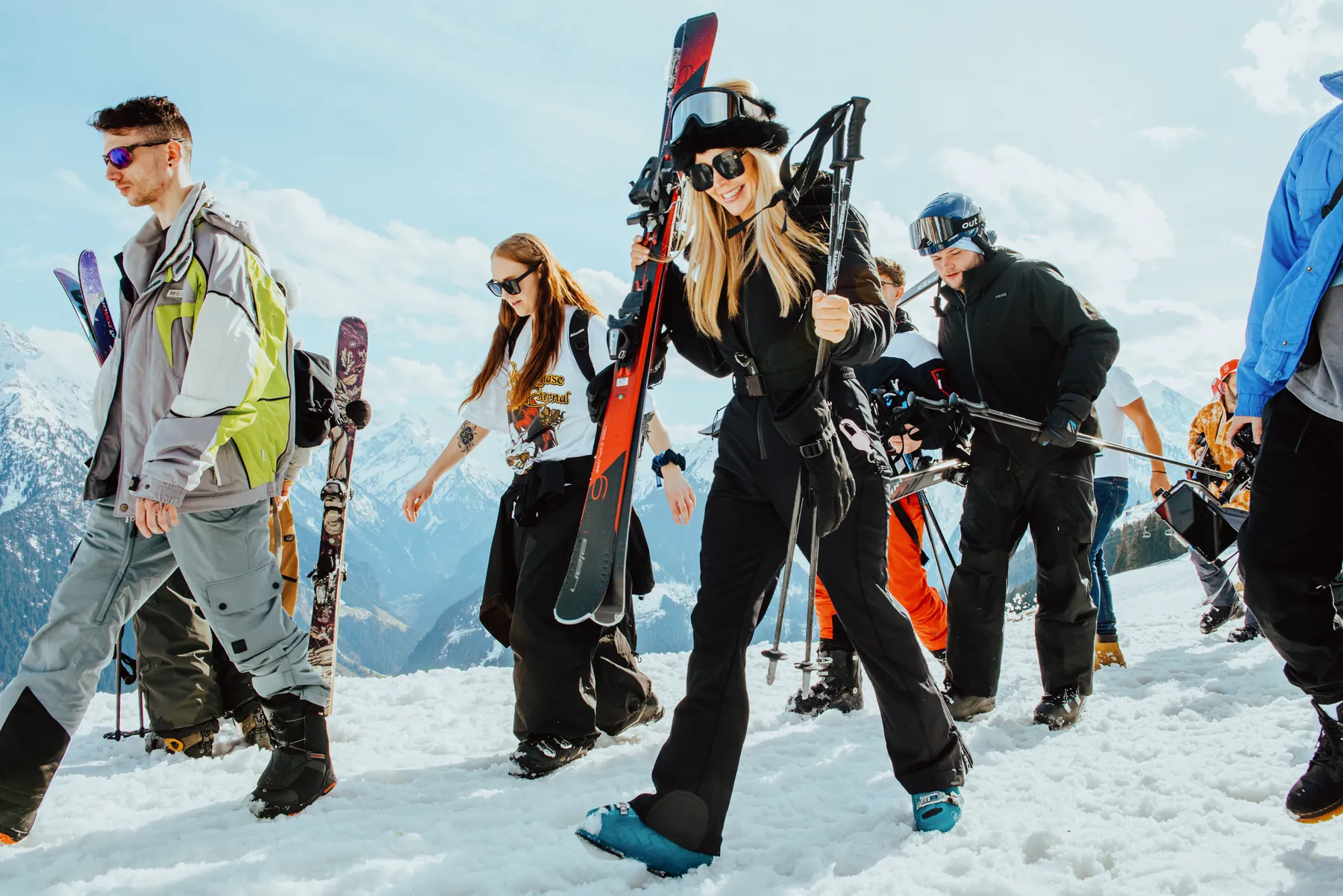 Snowbombing skiers hiking the mountain with skis